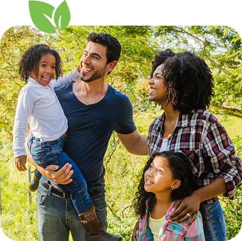 Smiling family standing together outdoors on a sunny day