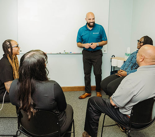 Pivotal Health staff participating in a group session led by a facilitator in front of a whiteboard