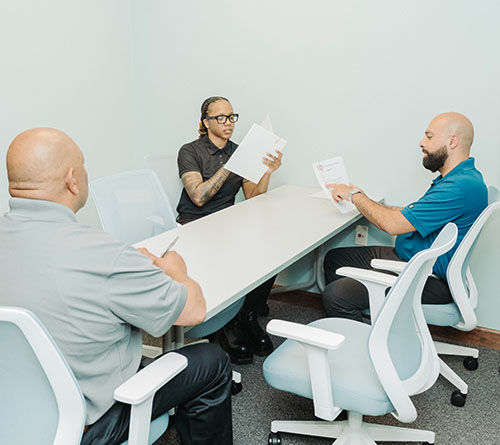 Pivotal Health team members seated at a small conference table reviewing documents