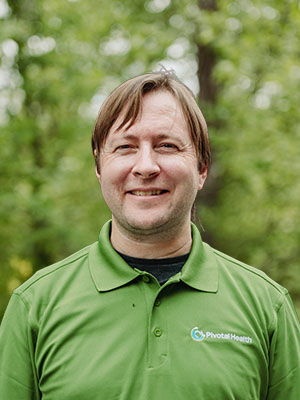 Pivotal Health team member in a green polo smiling outdoors