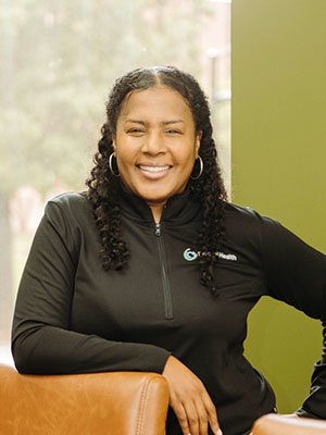 Pivotal Health team member smiling while seated indoors.